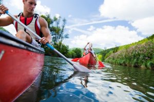 two boys kayaking on a river